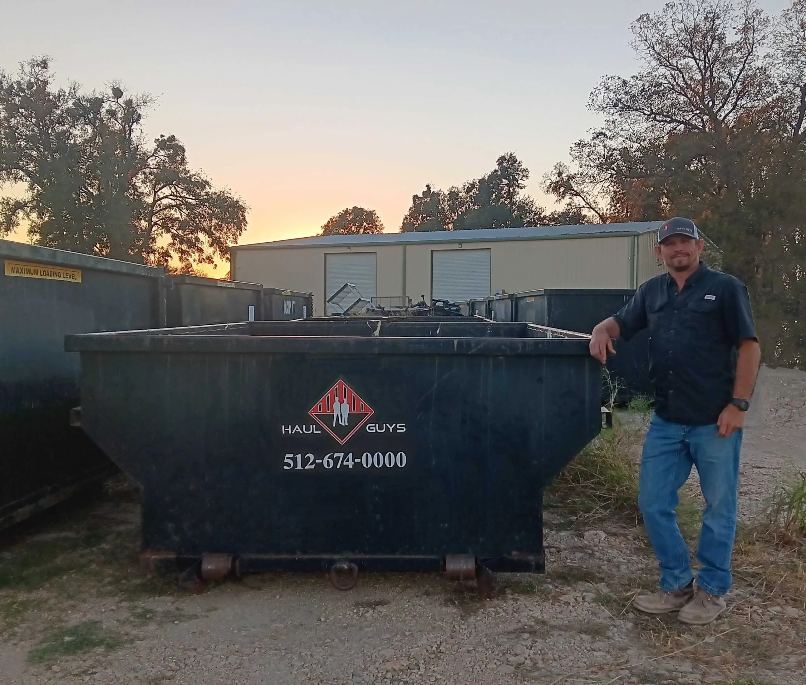a man standing next to a dumpster
